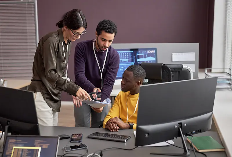 GettyImages-1475344755 Team collaborating in modern office setting.