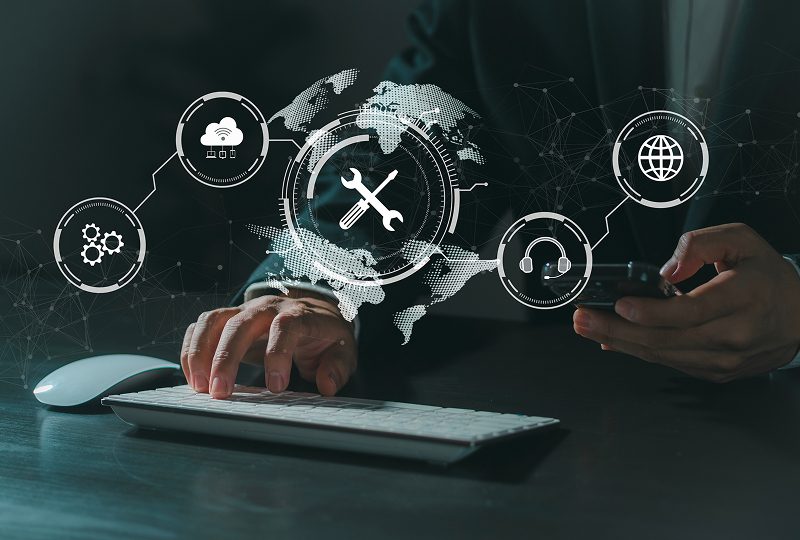 Person using computer with digital icons overlay.