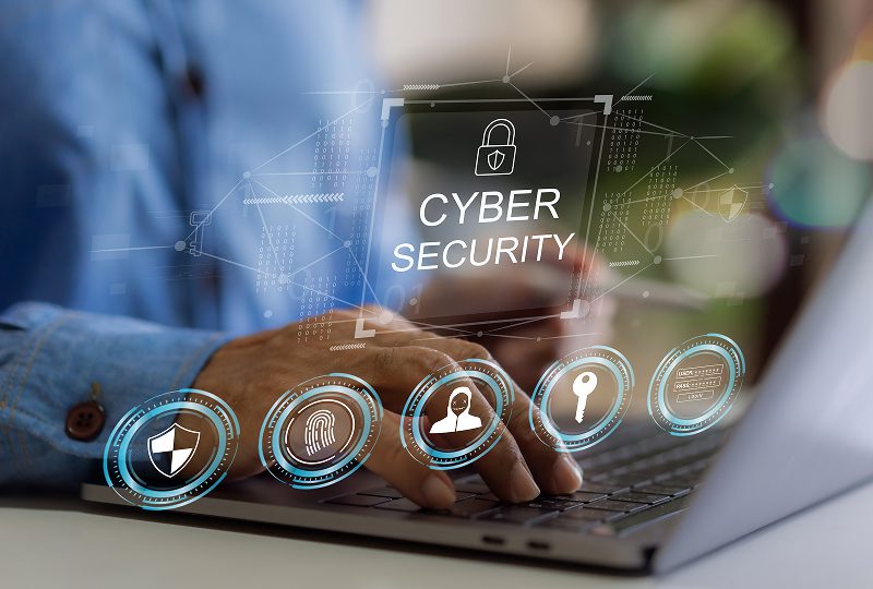 Person typing with cybersecurity graphics overlay.